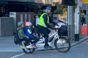 Man and two children riding e-bike