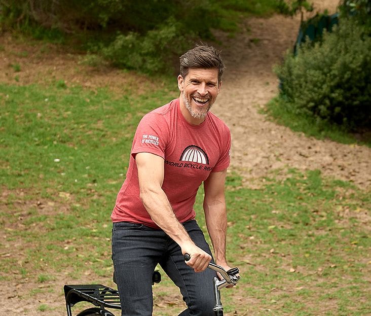 Osher Gunsberg riding a World Bicycle Relief bike