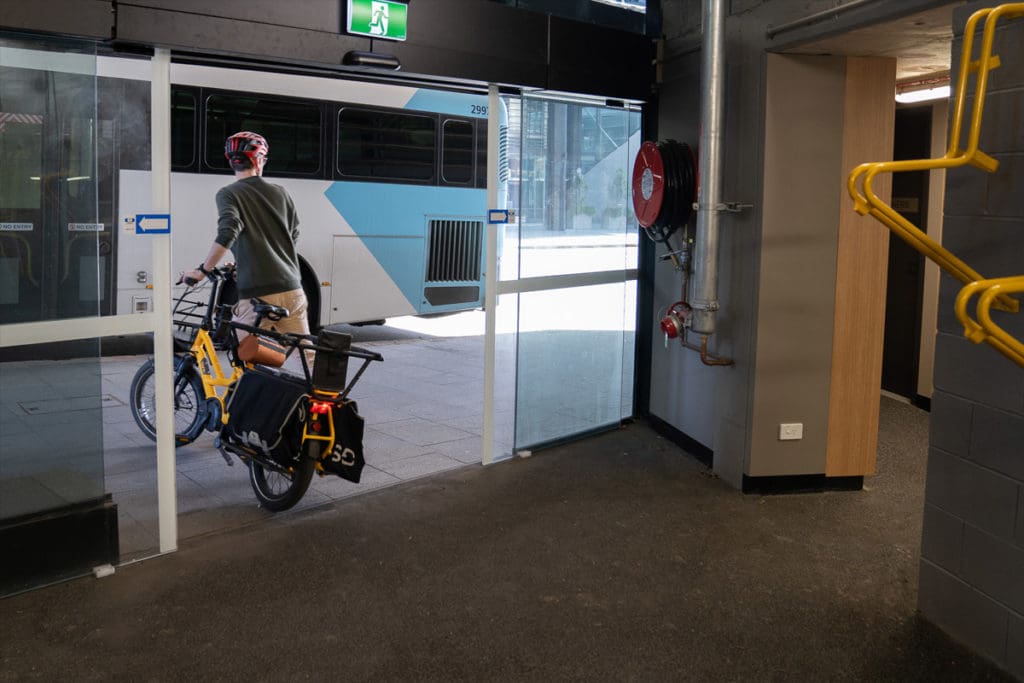 cyclist walking with bike out of building
