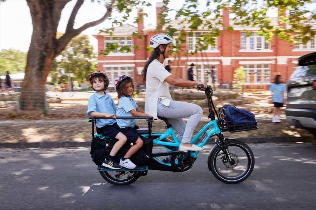 Family riding two-wheeled cargo bike
