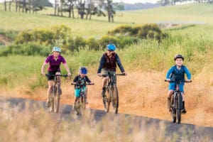 Family riding bicycles on path in rural setting