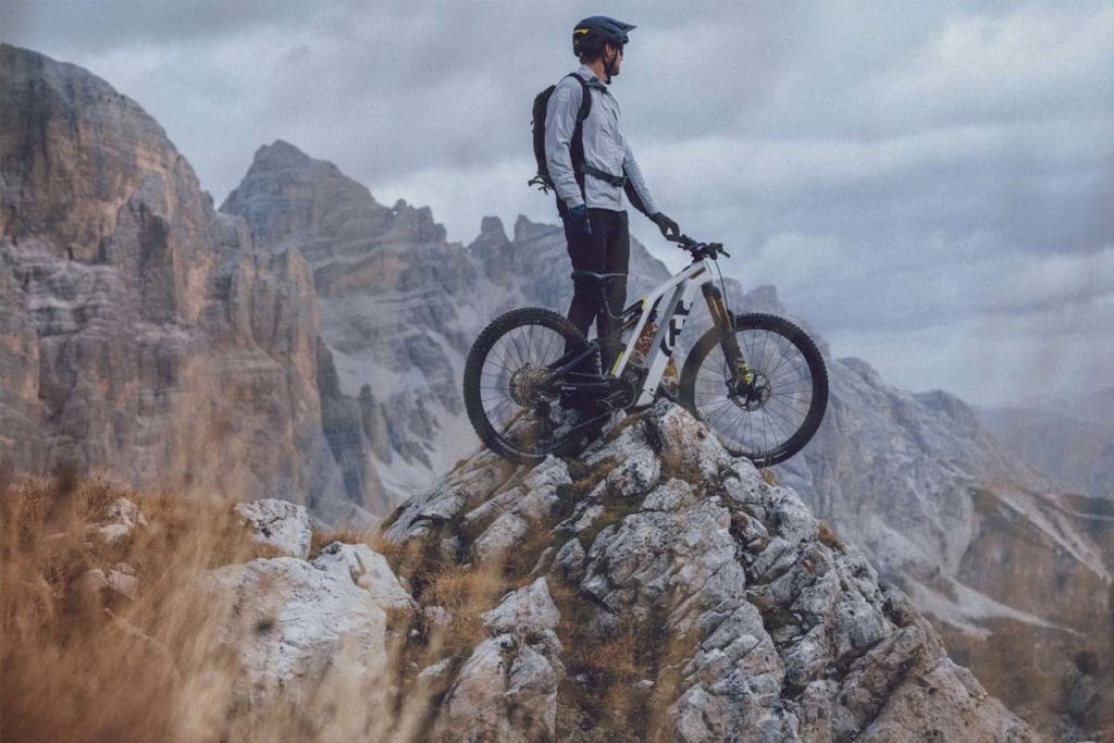 Person standing on top of mountain with bike