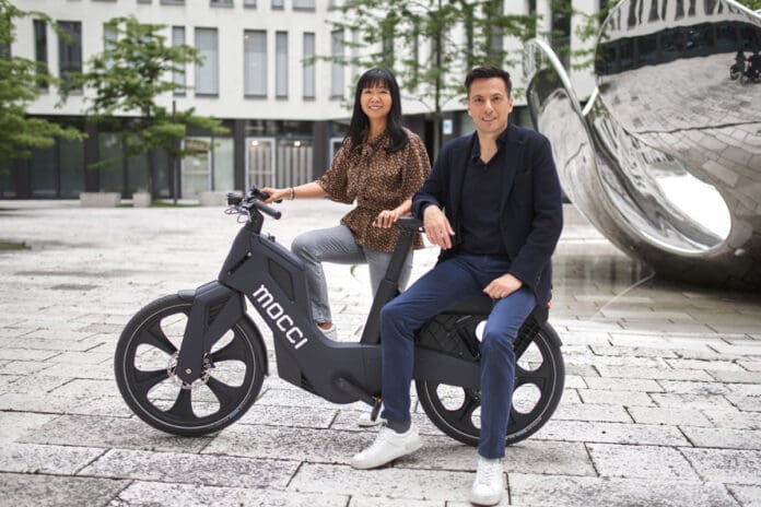Man and woman posing with the Mocci Smart Mobility Vehicle