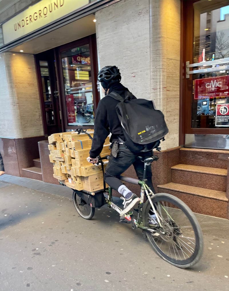 bicycle delivery person on city footpath