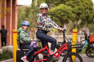 Mother riding electric bike with daughter on the back