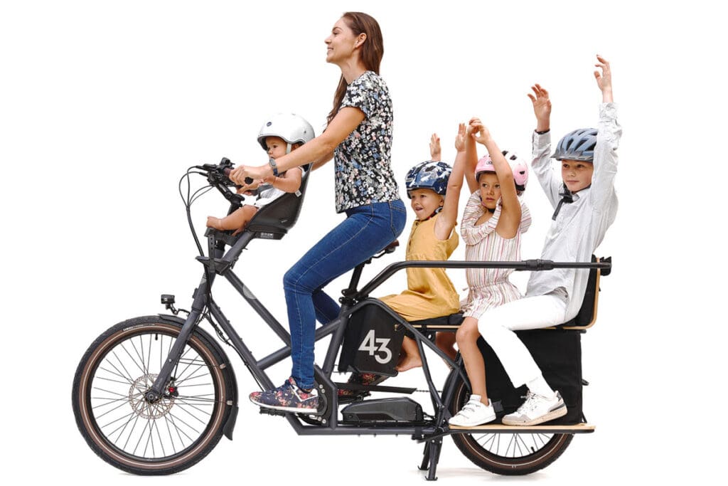 Woman and four children riding e-cargo bike