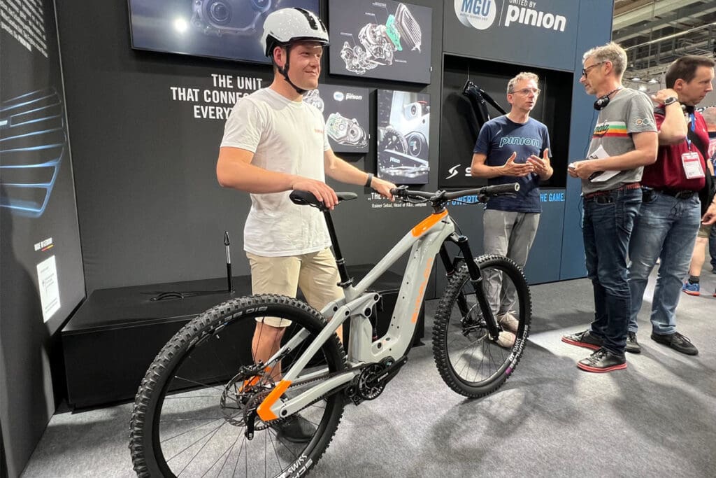 Person wearing helmet standing with ebike at expo
