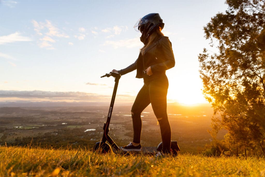 Person with e-scooter with mountain background