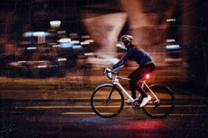 Person riding bicycle on the road at night