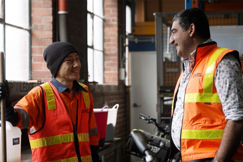 Two men in warehouse wearing high vis vests