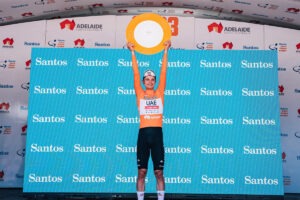 Winner of cycling race holding up trophy