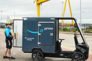 A delivery person loading parcel into a light electric vehicle