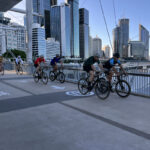 Cyclists riding across a city bridge