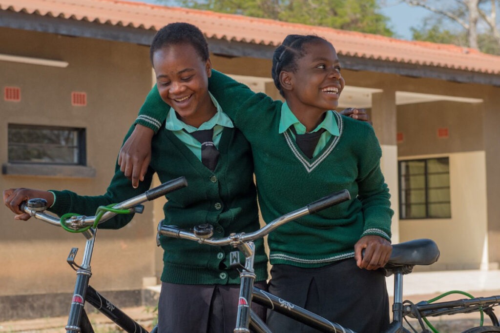 Two happy south African school girls with bicycles