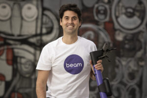 Portrait of Tom Cooper with an e-scooter wearing Beam shirt