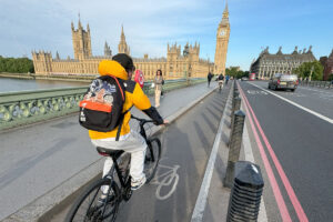 Person cycling on protected bicycle lane over Westminster Bridge, London.