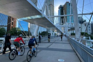 Cyclists riding across a city bridge.