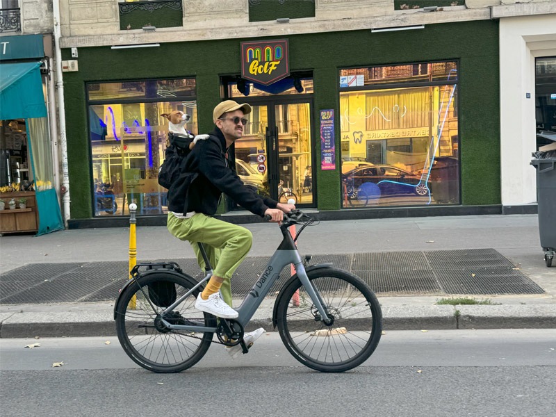 Cyclist with dog in backpack.