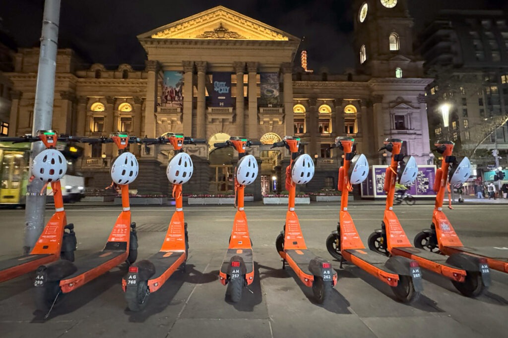 E-scooters parked in a row on the street.