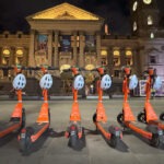 E-scooters parked in a row on the street.