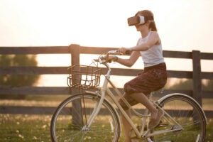 Person riding bike wearing virtual reality goggles