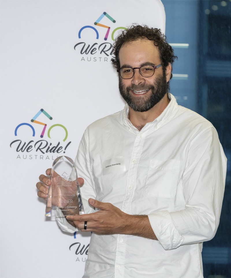 Man standing for portrait with a trophy.