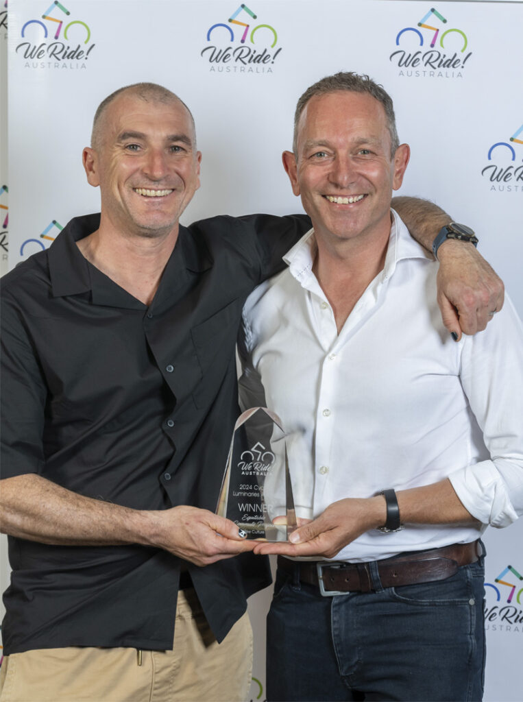 Two people standing for portrait with a trophy.