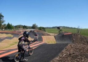People riding on a bike pump track