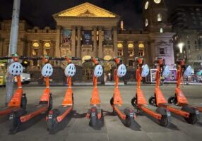 E-scooters parked in a row on the street.